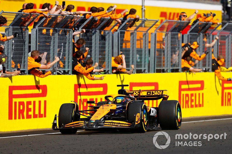 Oscar Piastri, McLaren MCL38, 1st position, passes his celebrating team on the pit wall at the end of the race