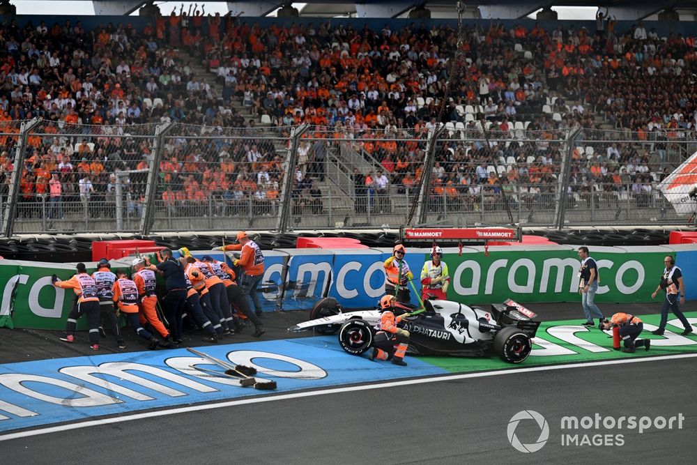 Marshals repair the barriers and deal with the damaged car of Daniel Ricciardo, AlphaTauri AT04