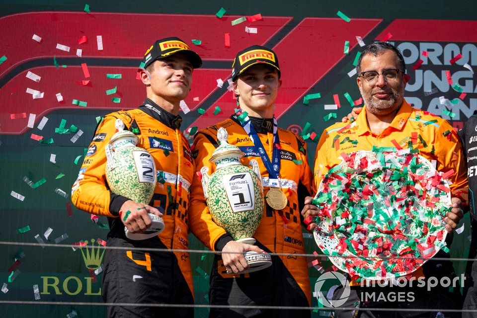 Lando Norris, McLaren F1 Team, 2nd position, Oscar Piastri, McLaren F1 Team, 1st position, the McLaren trophy delegate with the trophies on the podium