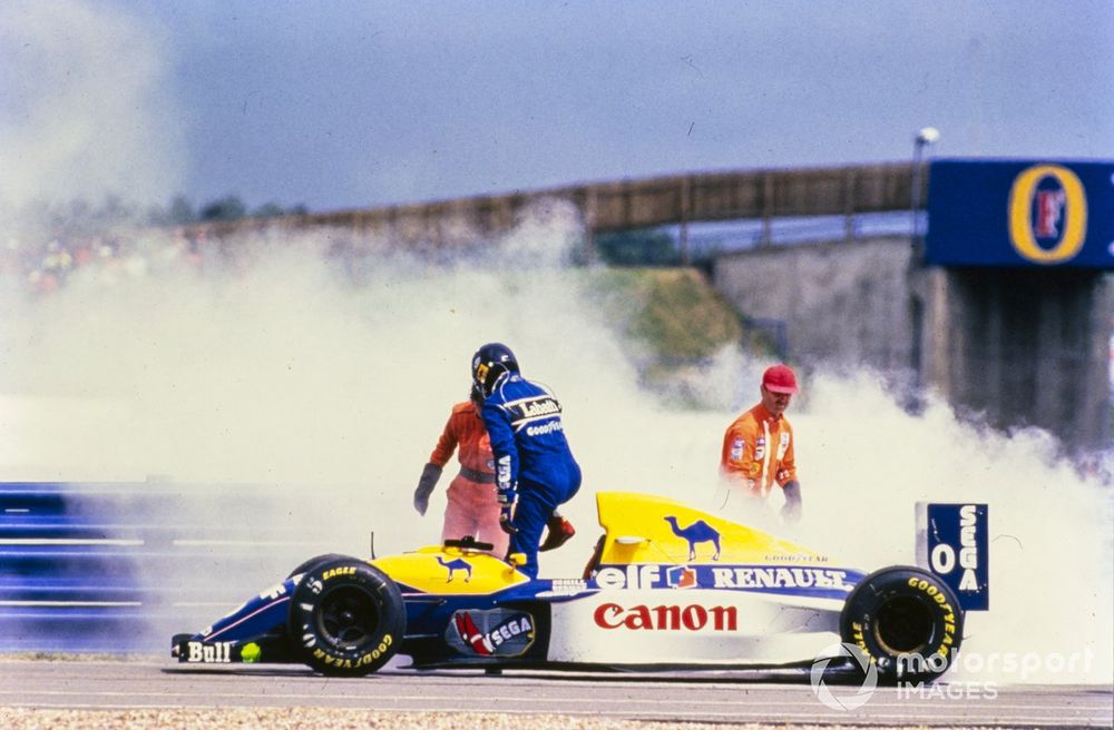 Marshals extinguish the smoking car of Damon Hill, Williams FW15C Renault.