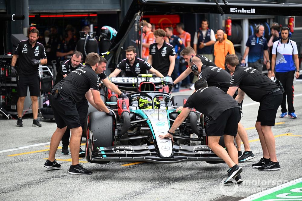 Mechanics of Mercedes AMG push Lewis Hamilton, Mercedes F1 W15, back into the garage 