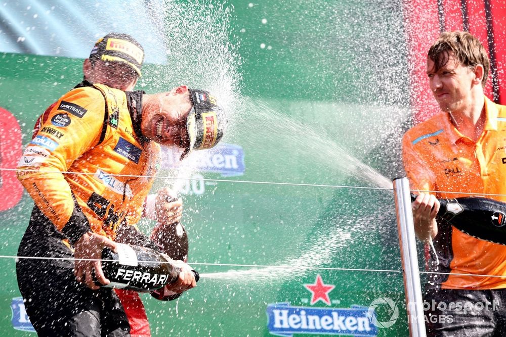 The McLaren trophy delegate sprays Lando Norris, McLaren F1 Team, 1st position, with Champagne on the podium