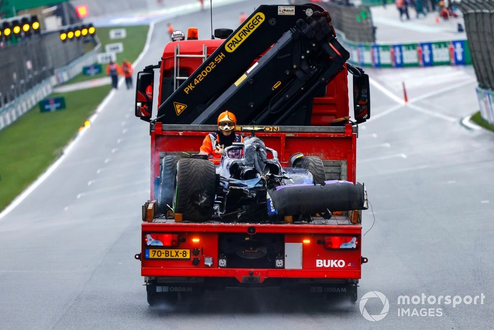 A marshal with the damaged car of Logan Sargeant, Williams FW46, on a truck