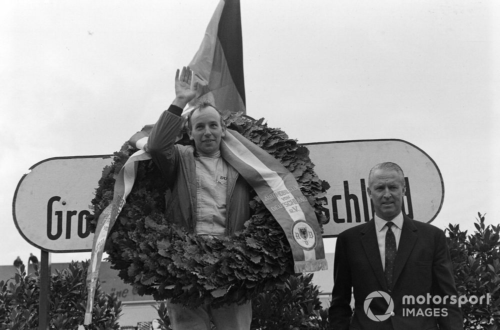 John Surtees, 1st position, celebrates on the podium.