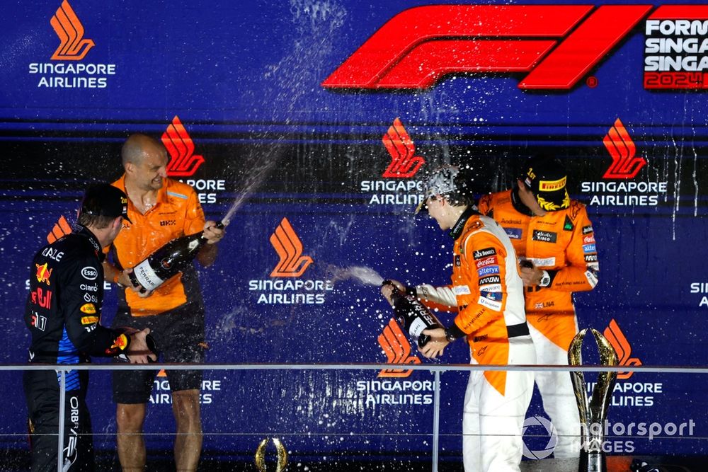 Max Verstappen, Red Bull Racing, 2nd position, the McLaren trophy delegate, Lando Norris, McLaren F1 Team, 1st position, Oscar Piastri, McLaren F1 Team, 3rd position, spray Champagne on the podium