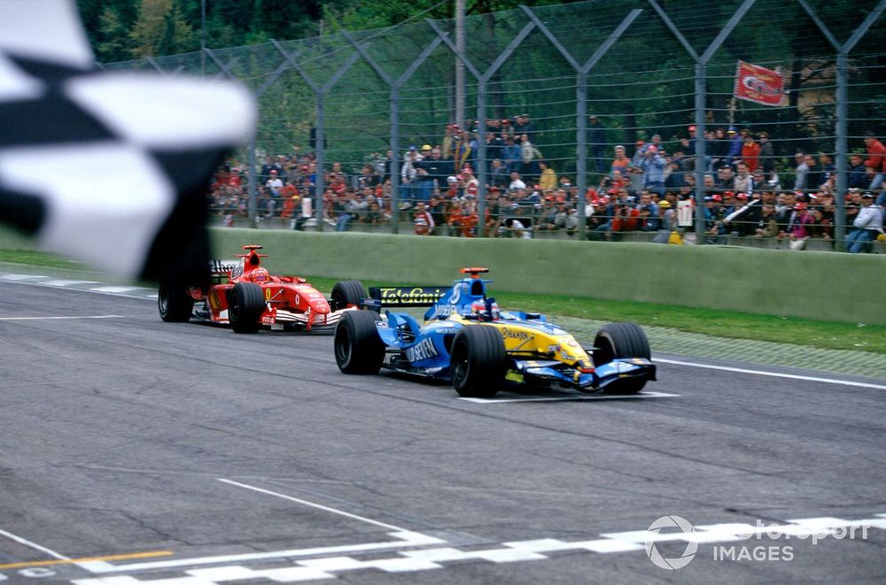 Race winner Fernando Alonso, Renault R25, takes the chequered flag, closely followed by Michael Schumacher, Ferrari F2005