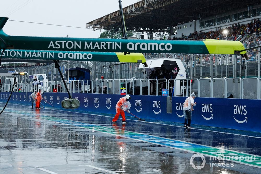 Marshals sweep water from the track