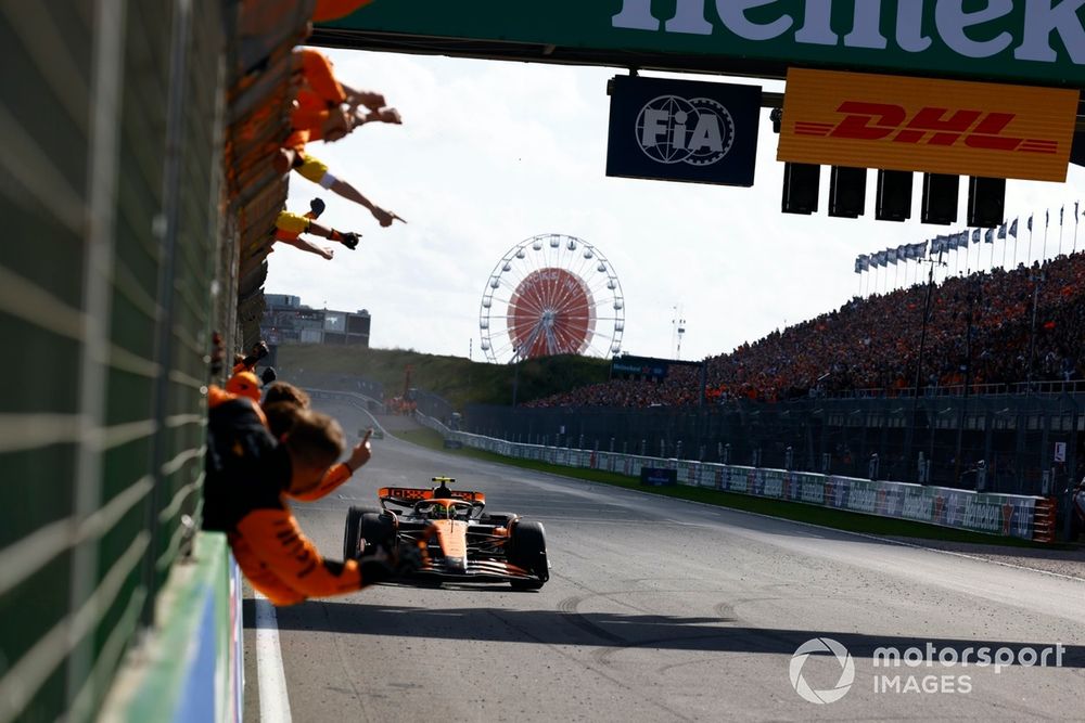 Lando Norris, McLaren MCL38, 1st position, takes the chequered flag as his team cheers from the pit wall