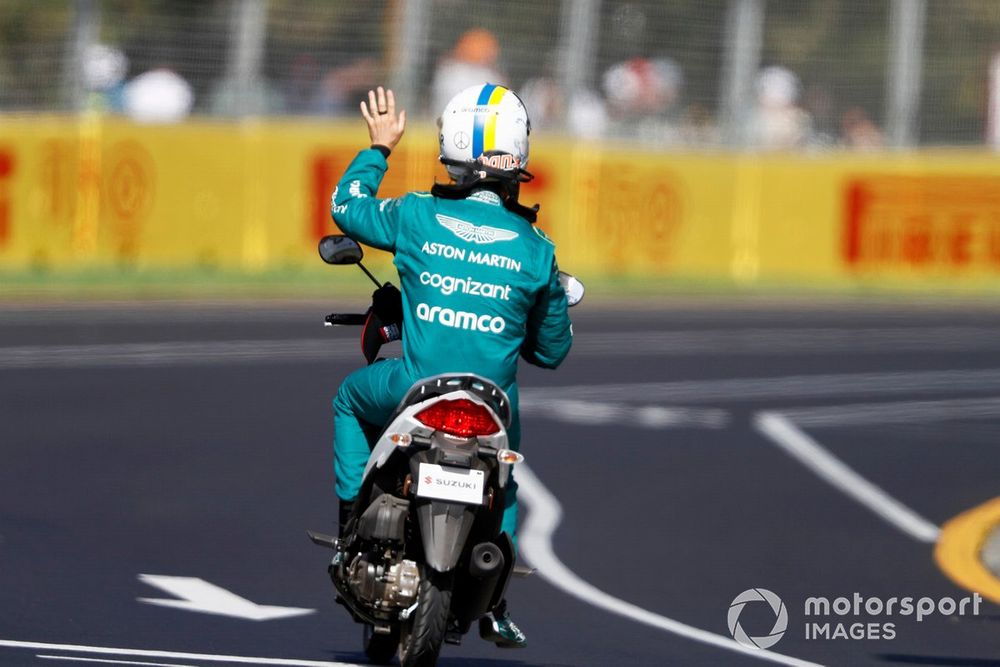 Sebastian Vettel, Aston Martin, gets a ride back to the pits 
