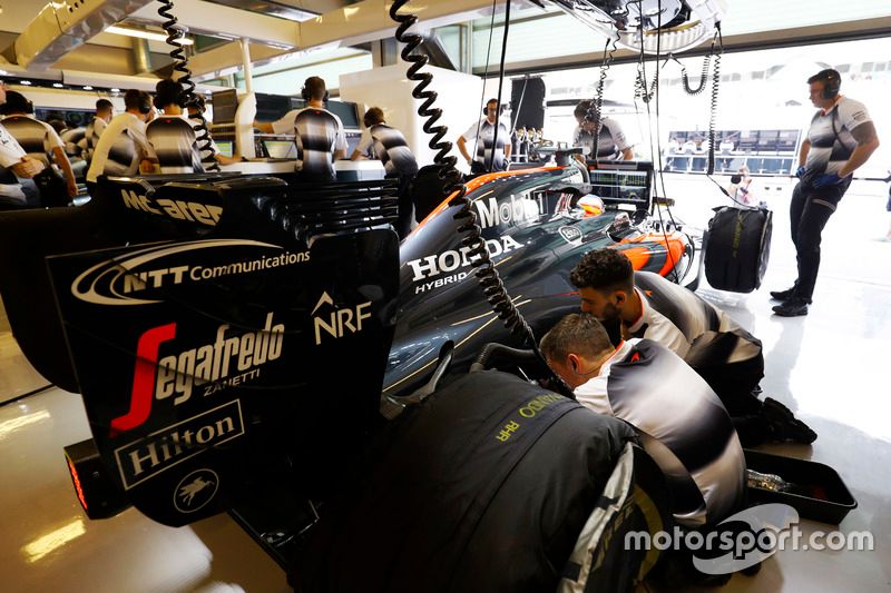 The team work on the car of Fernando Alonso, McLaren in the garage.